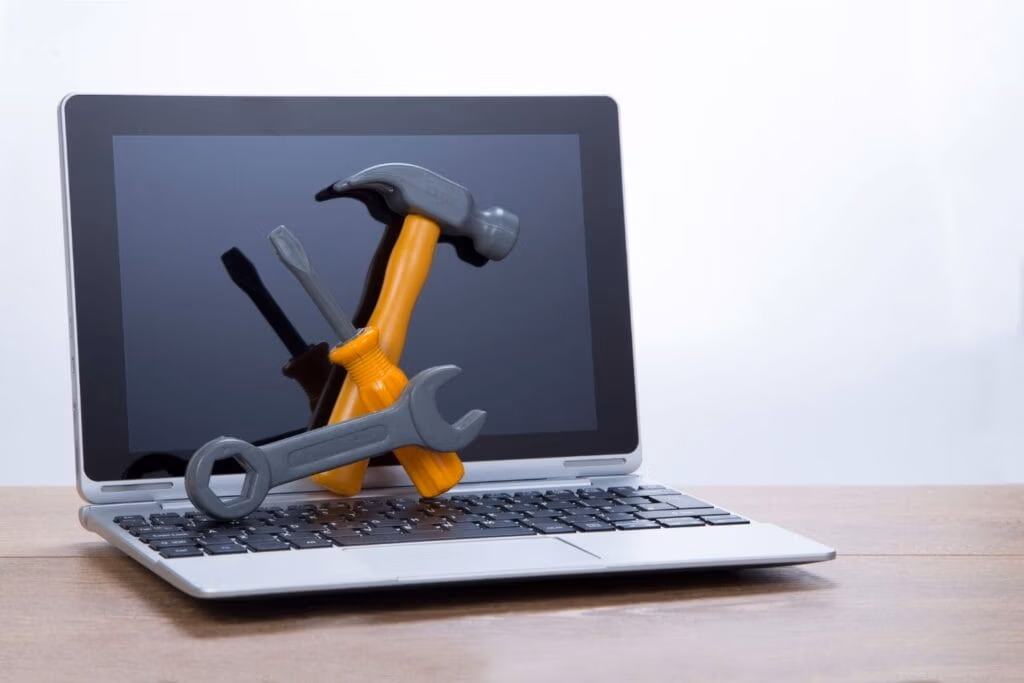 Laptop with maintenance tools representing ongoing WordPress website care